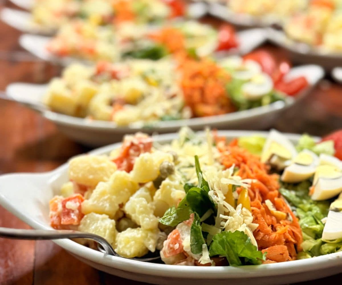 Fuentes de ensalada rusa con zanahoria rallada, huevo, tomate y lechuga